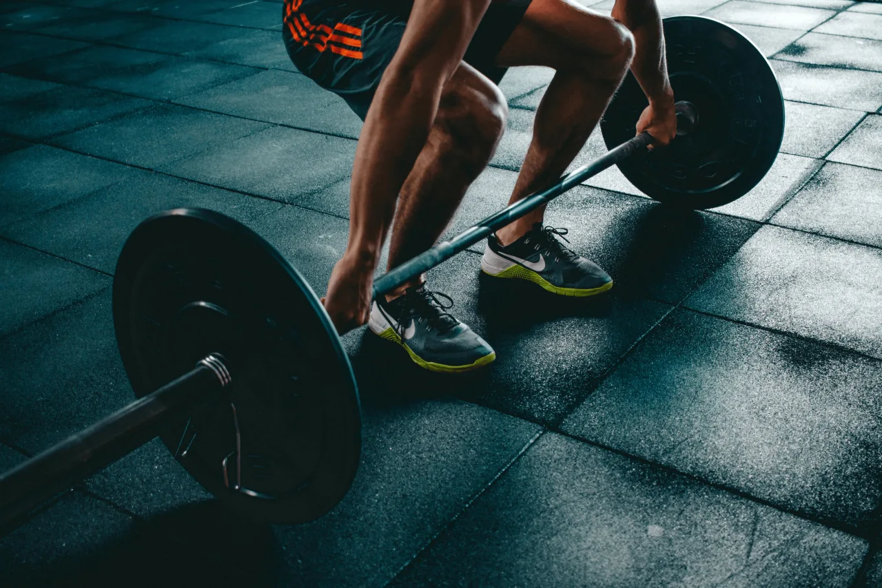 Coach assisting a member with barbell technique